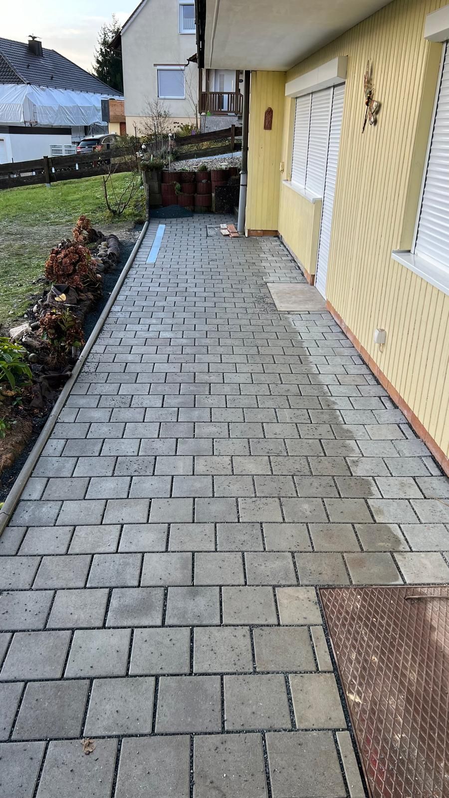 Ein Backsteinweg führt zu einem gelben Haus.