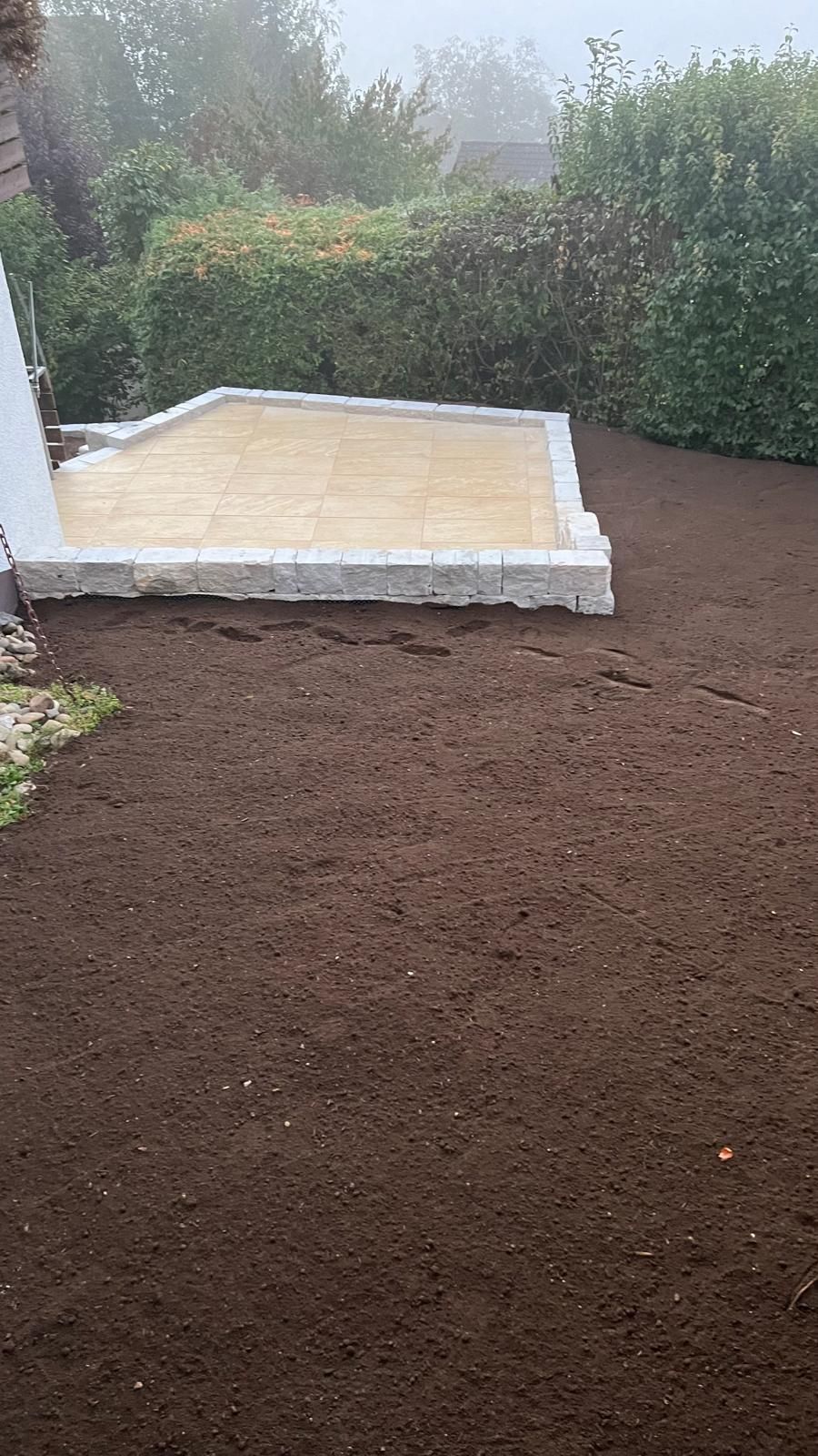 Im Hinterhof eines Hauses wird eine Terrasse gebaut.