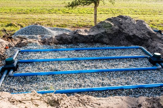 Installation d’un système d’épandage avec canalisations enterrées pour le traitement des eaux usées d’une fosse toutes eaux.