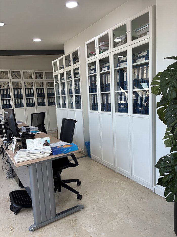 Una habitación con muchos armarios y un escritorio con una computadora encima.