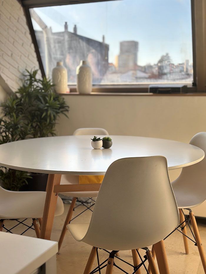 Una mesa y sillas en una habitación con ventana.