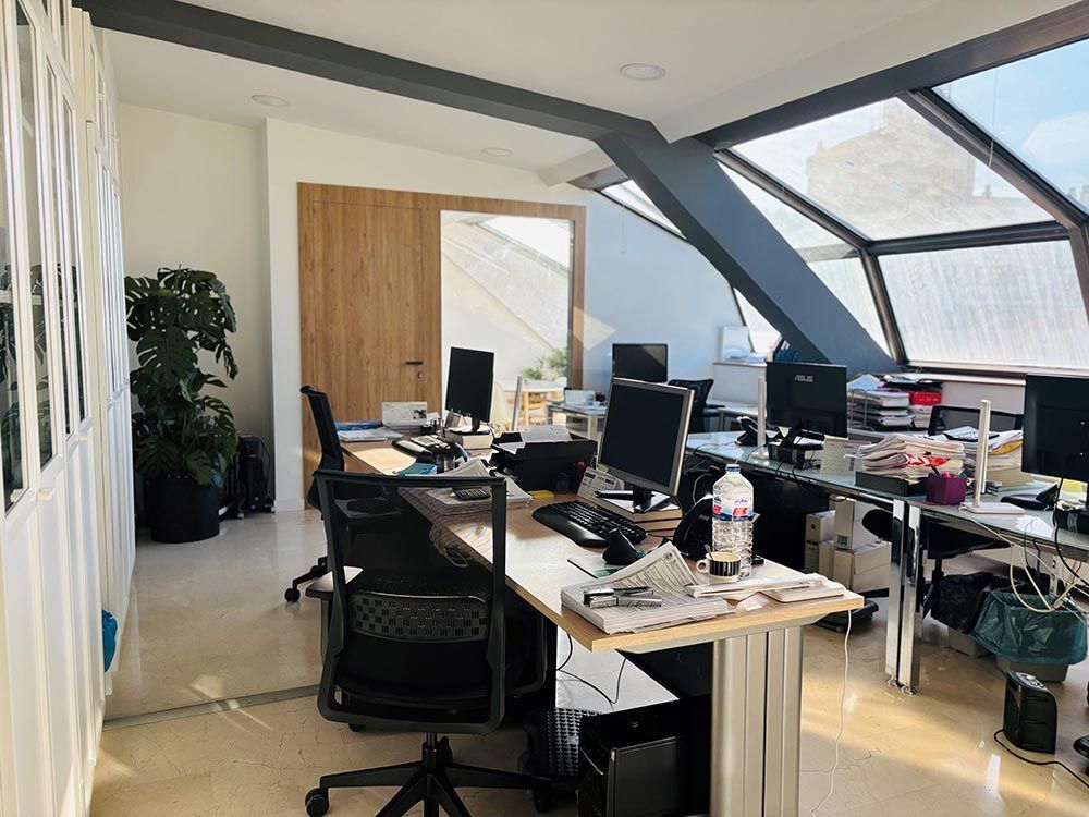 Hay muchas computadoras en los escritorios de esta oficina.