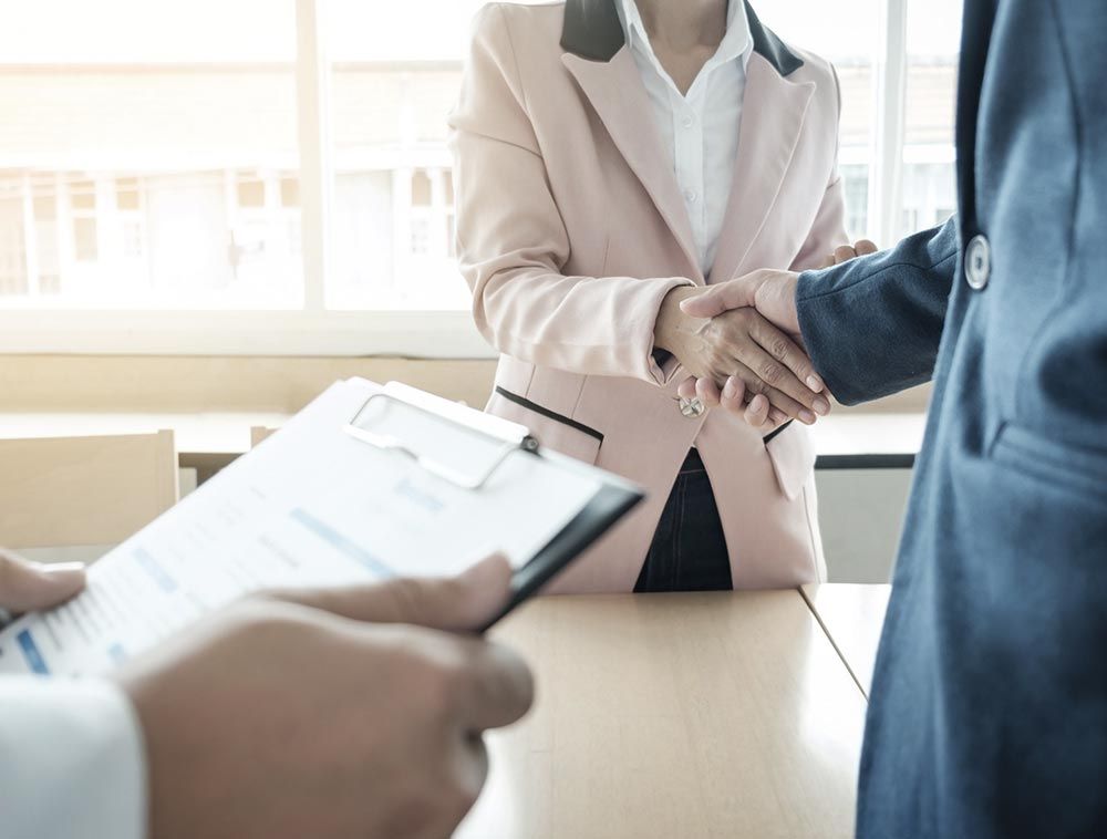 Un hombre y una mujer se dan la mano en una mesa.