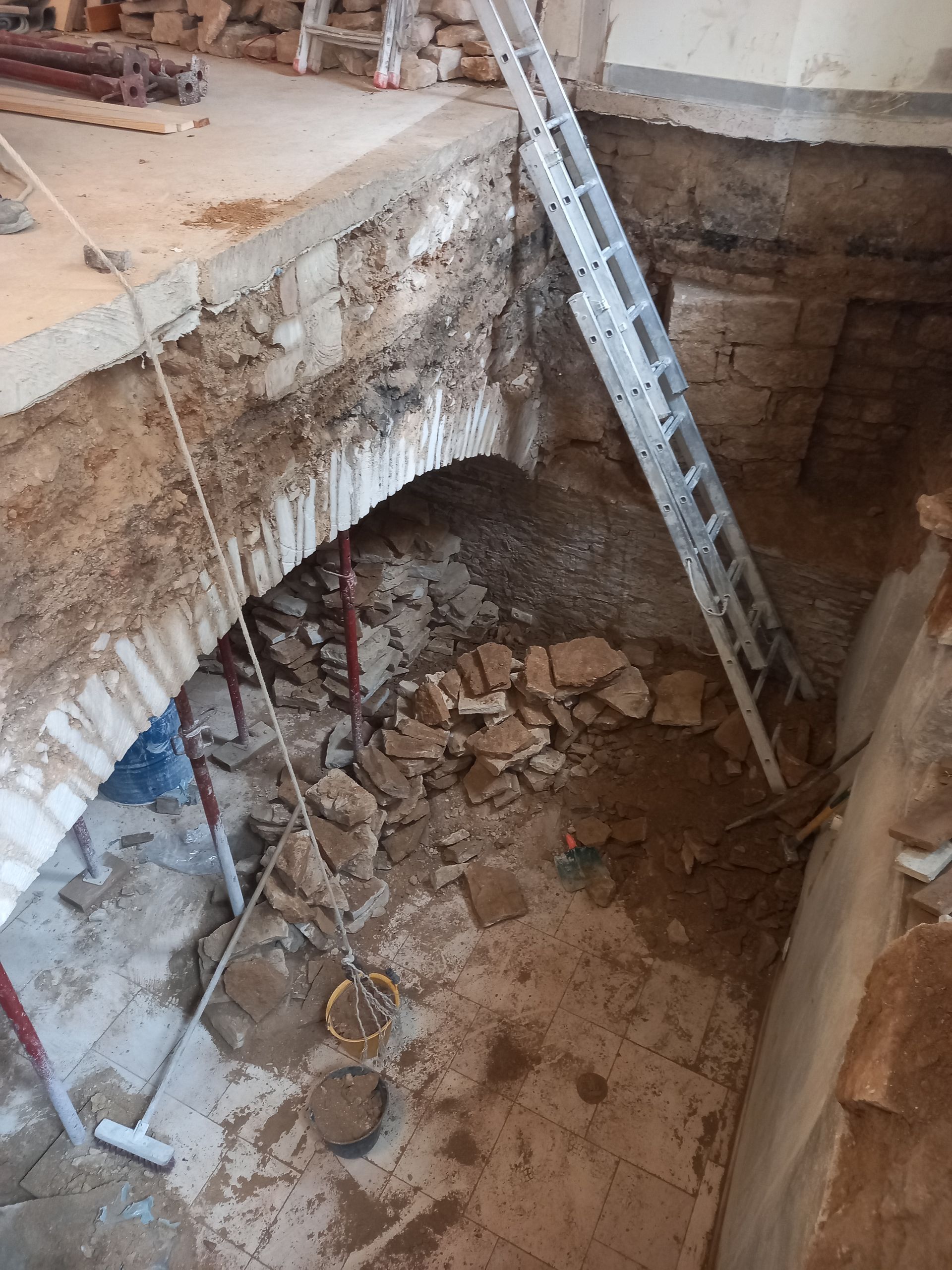 Sciage de voûte en pierre et sol en béton.