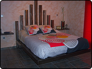 Una cama en un dormitorio con cabecero de madera.