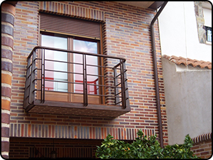 Un balcón en el costado de un edificio de ladrillo.