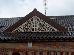 Un edificio de ladrillo con un triángulo encima.