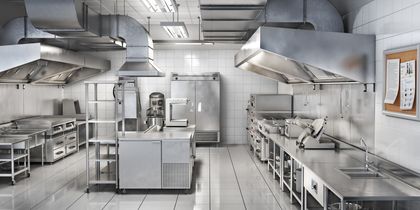 Una gran cocina comercial con muchos electrodomésticos de acero inoxidable.
