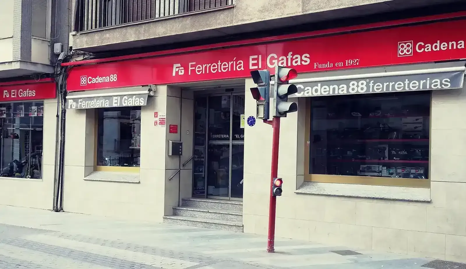 Una tienda con un toldo rojo que dice ferretería el gafas
