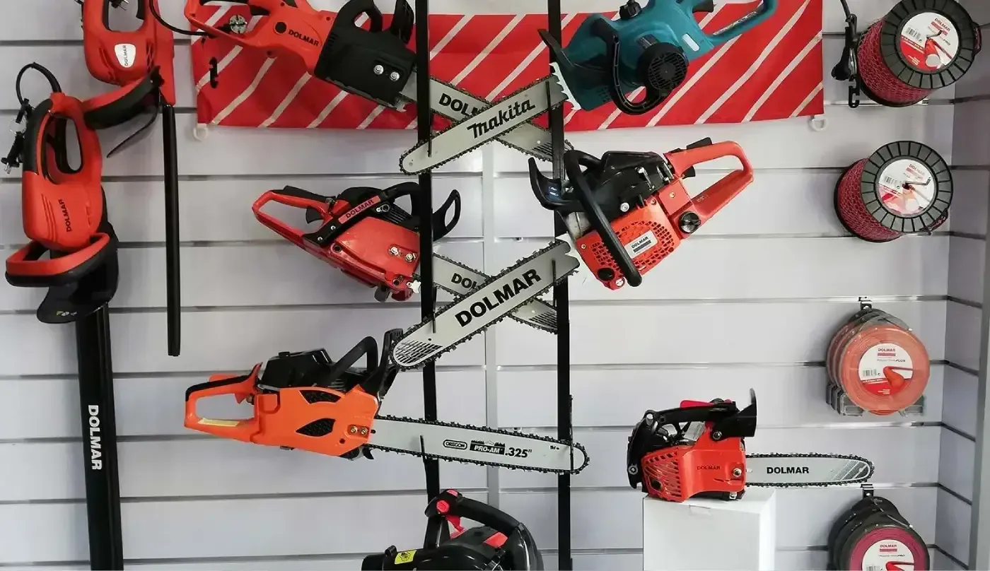 Un montón de motosierras están colgadas en una pared