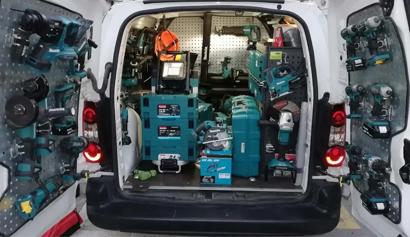 La parte trasera de una camioneta llena de herramientas y cajas.