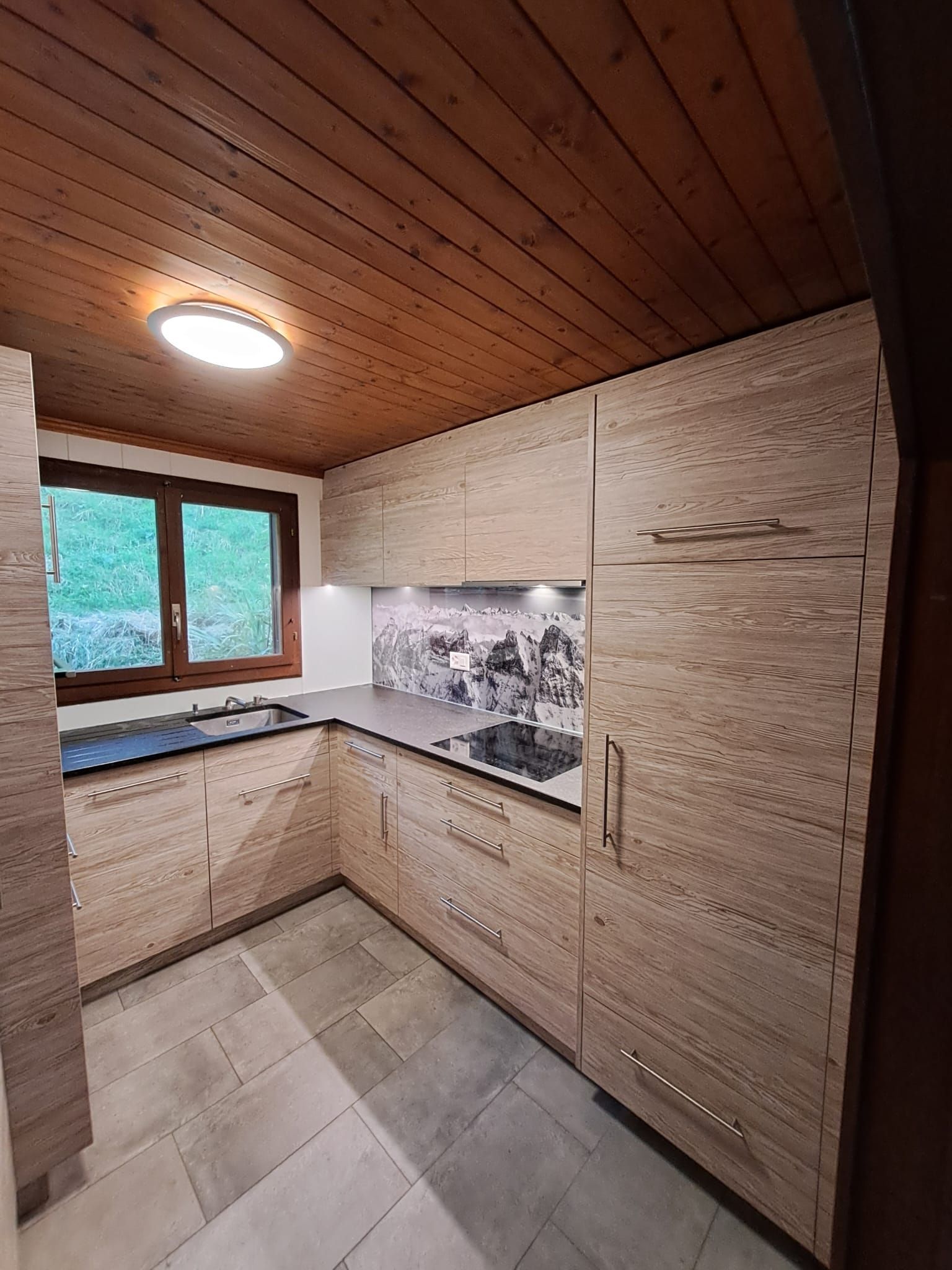 Cuisine stratifié imitation bois avec entre meuble en verre et photo panoramique