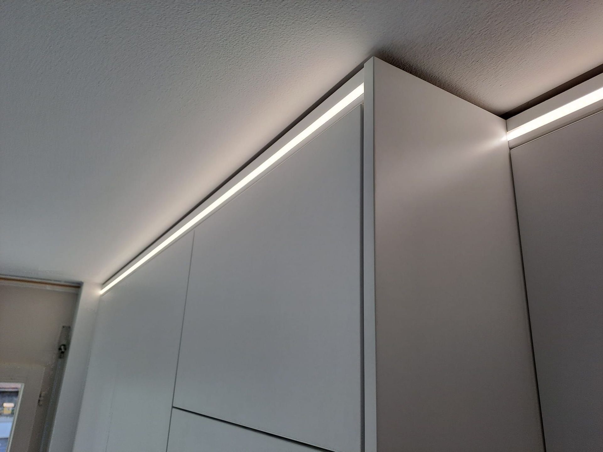 Cuisine en stratifié avec poignée profilée noir, crédence en miroir bronze, plan de travail dekton Laurent