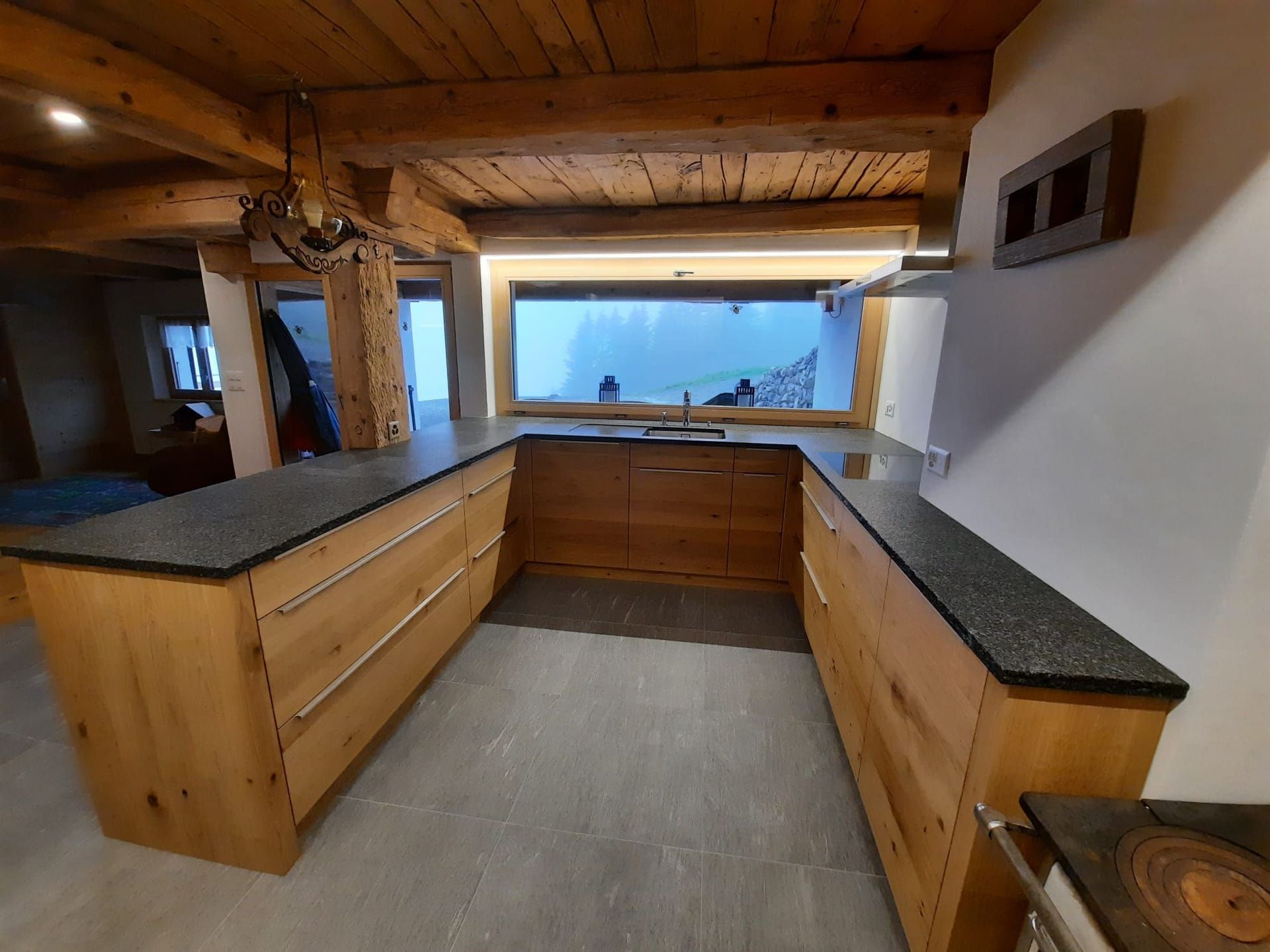 Cuisine neuve en chêne dans un chalet rénové rempli de charme - Plan de travail Impala, champs bruts - poignées inox