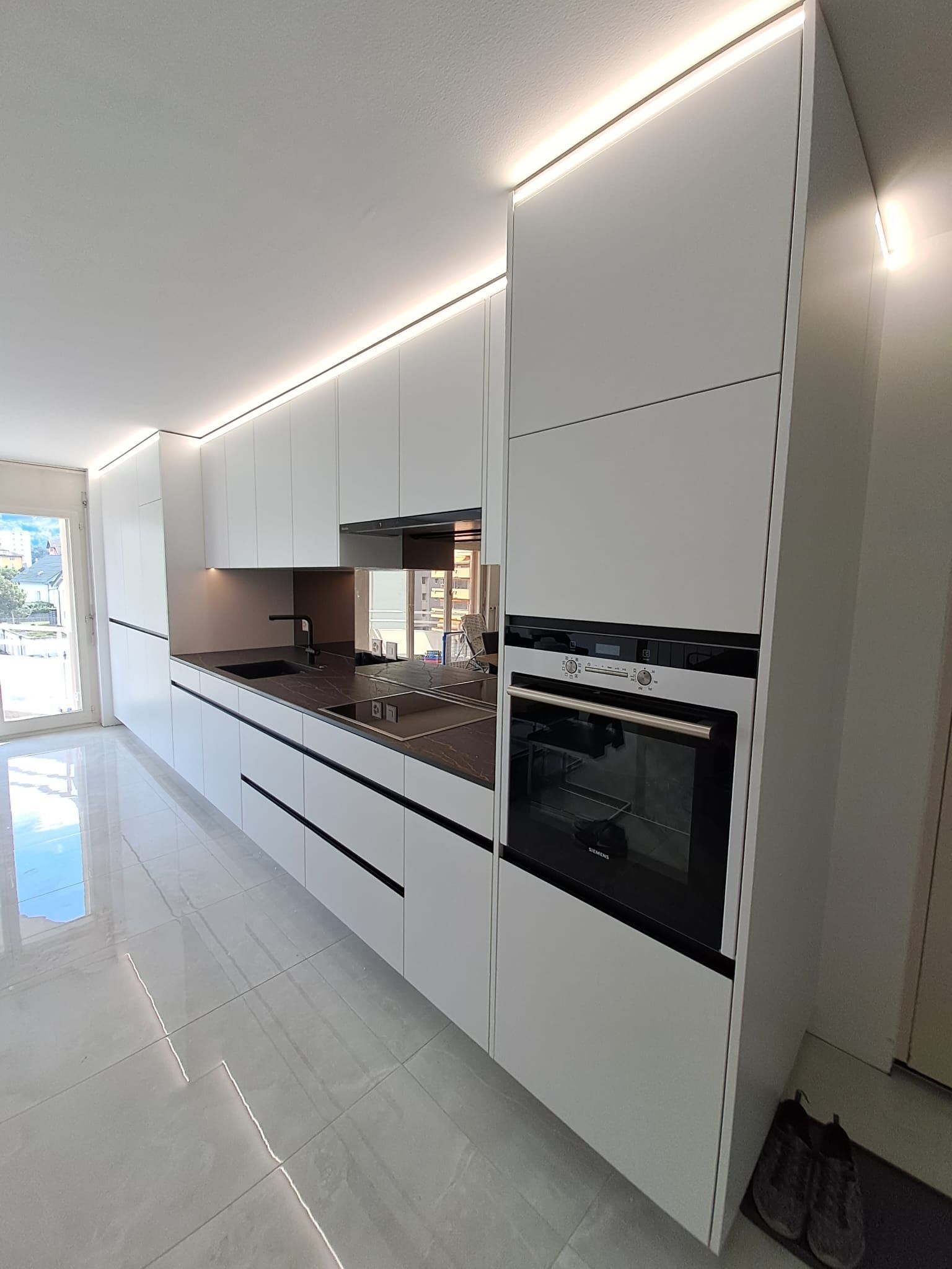 Cuisine en stratifié avec poignée profilée noir, crédence en miroir bronze, plan de travail dekton Laurent