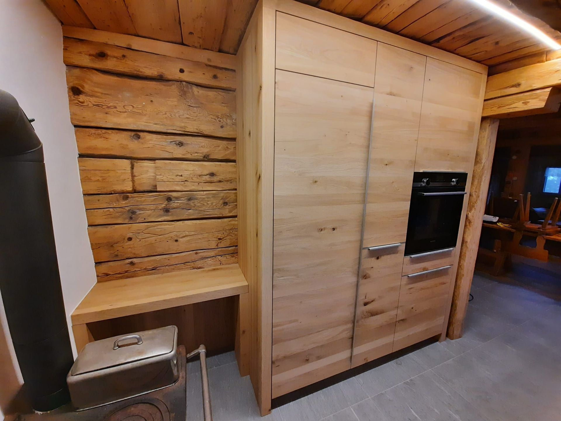 Cuisine neuve en chêne dans un chalet rénové rempli de charme - Plan de travail Impala, champs bruts - poignées inox