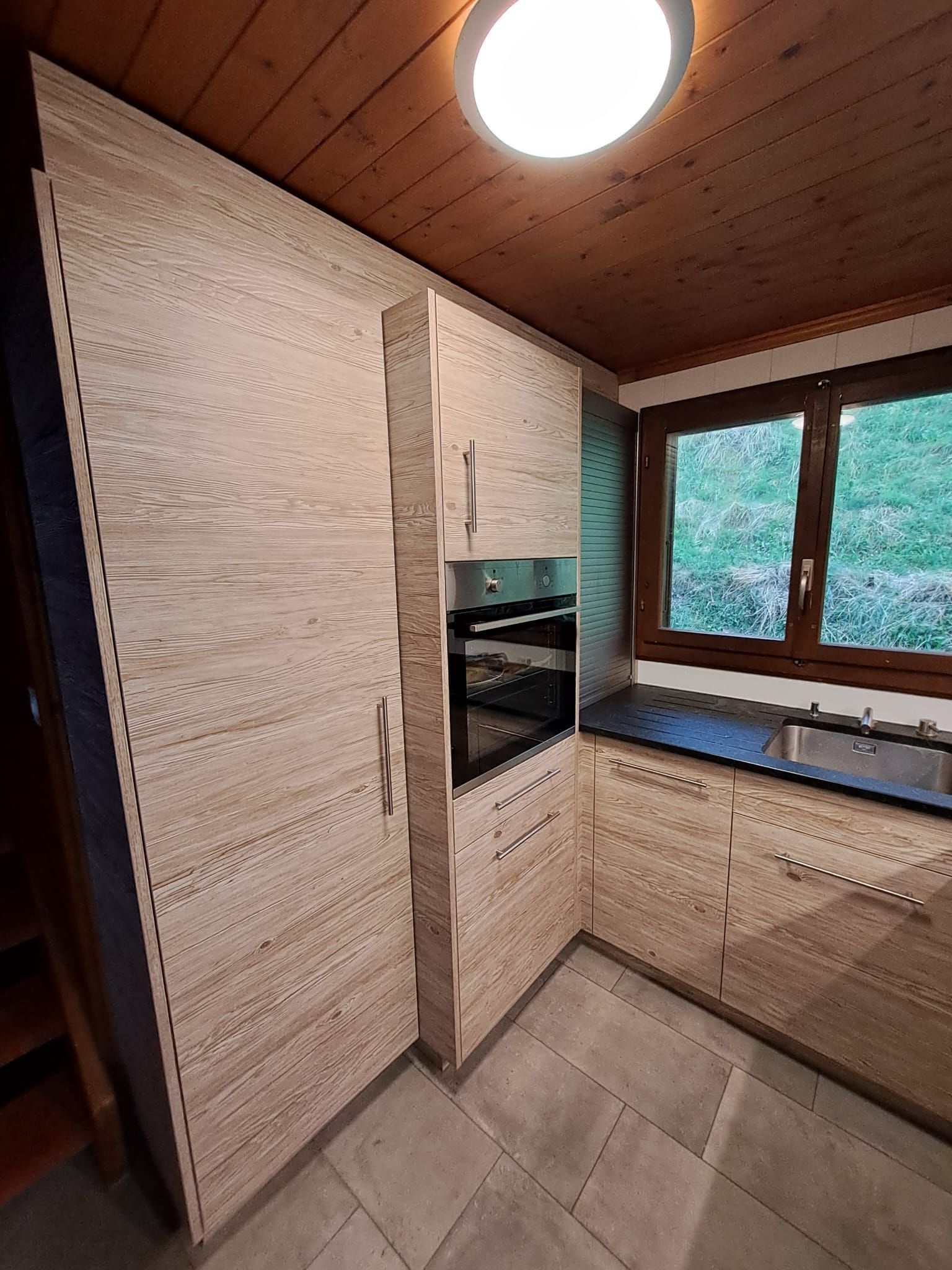 Cuisine stratifié imitation bois avec entre meuble en verre et photo panoramique