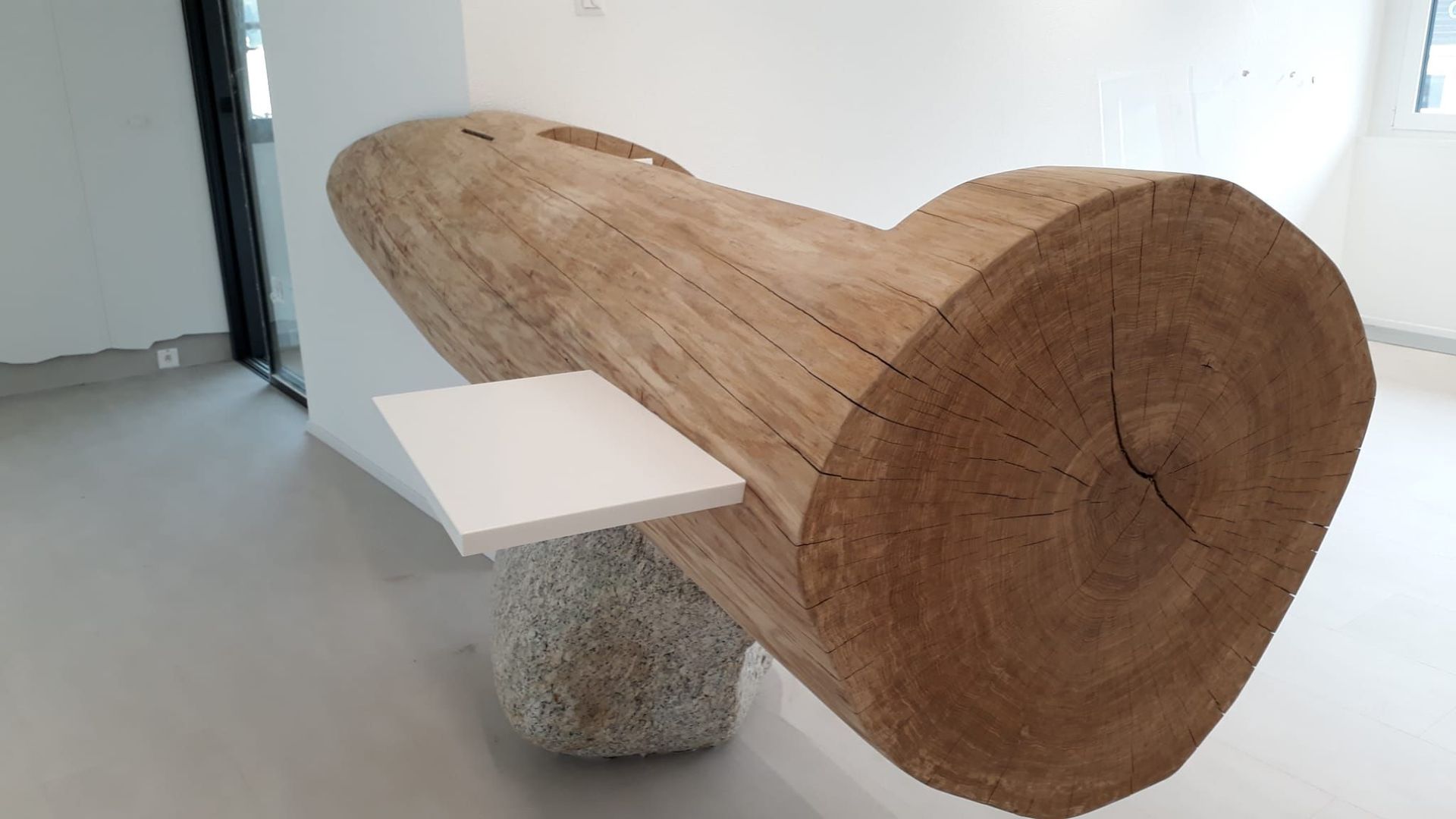 Raiffeisen Troistorrents: Guichet creusé dans une bille de chêne et posé sur une pierre, vue à de l'avant