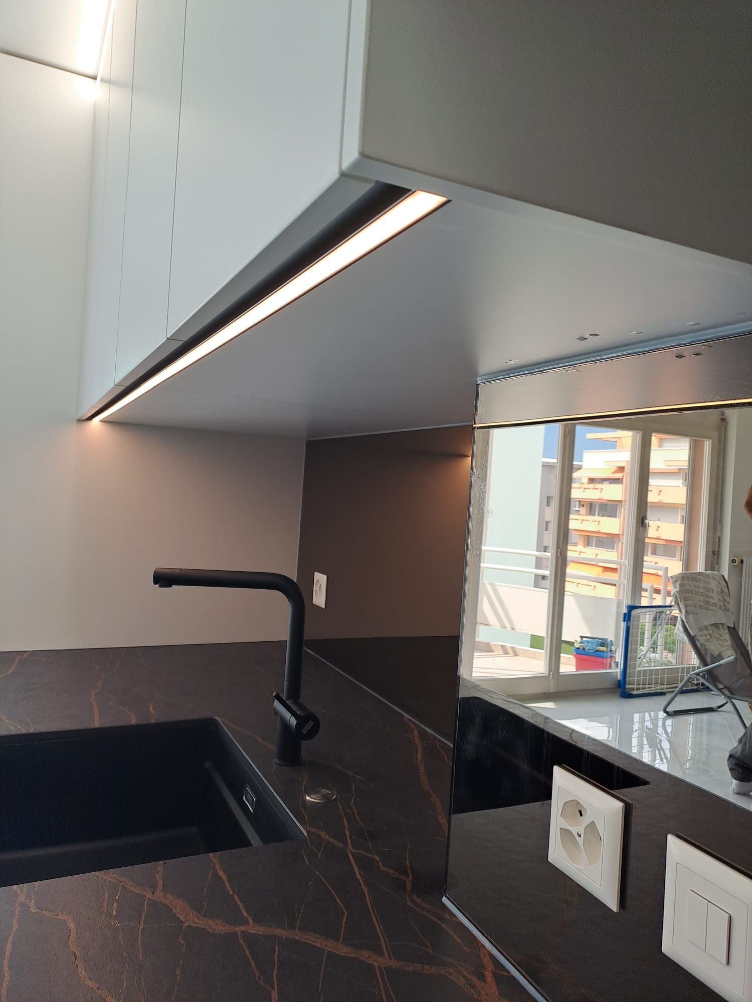 Cuisine en stratifié avec poignée profilée noir, crédence en miroir bronze, plan de travail dekton Laurent