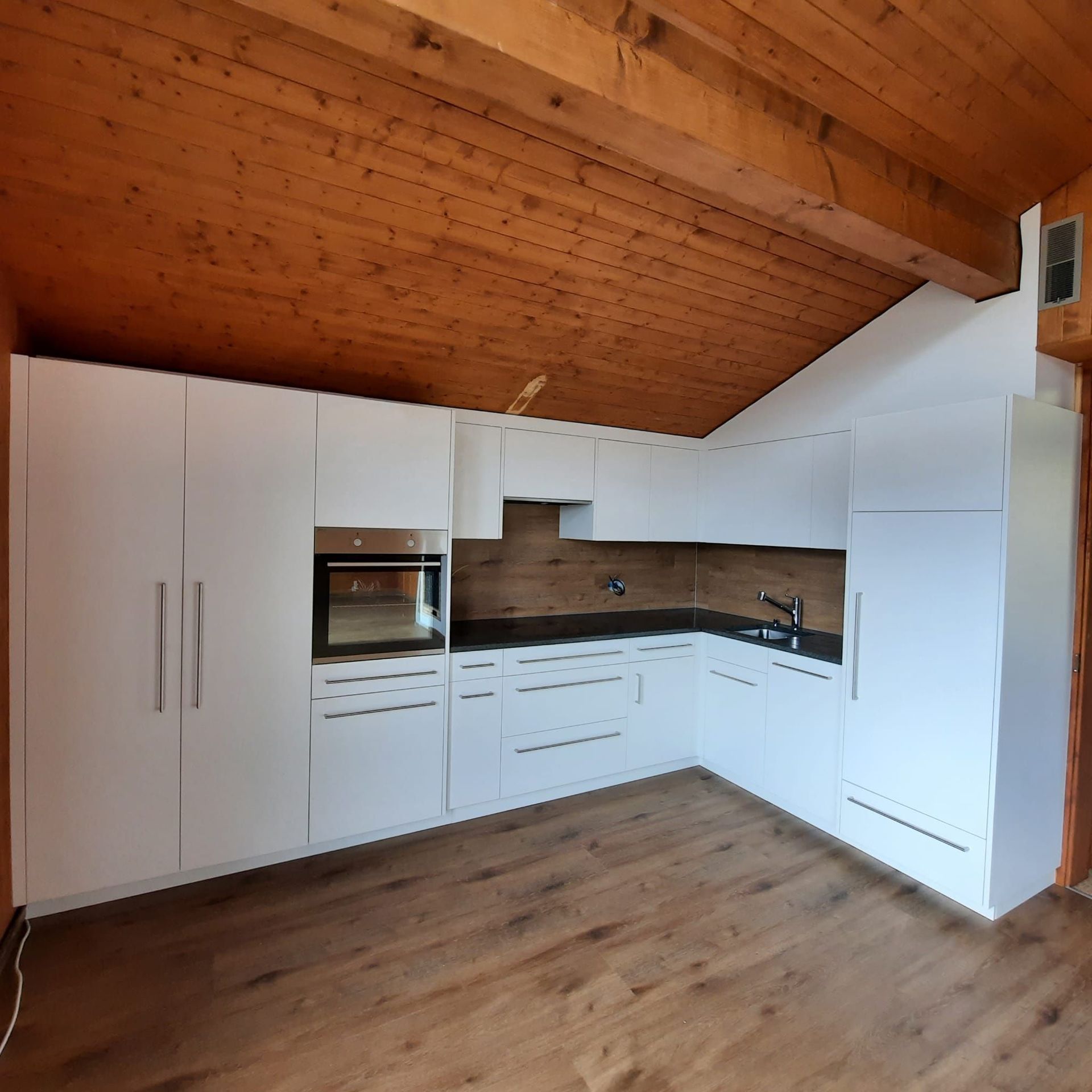 Cuisine blanche, plan de travail en granit noir, sol et entre-meuble identique!