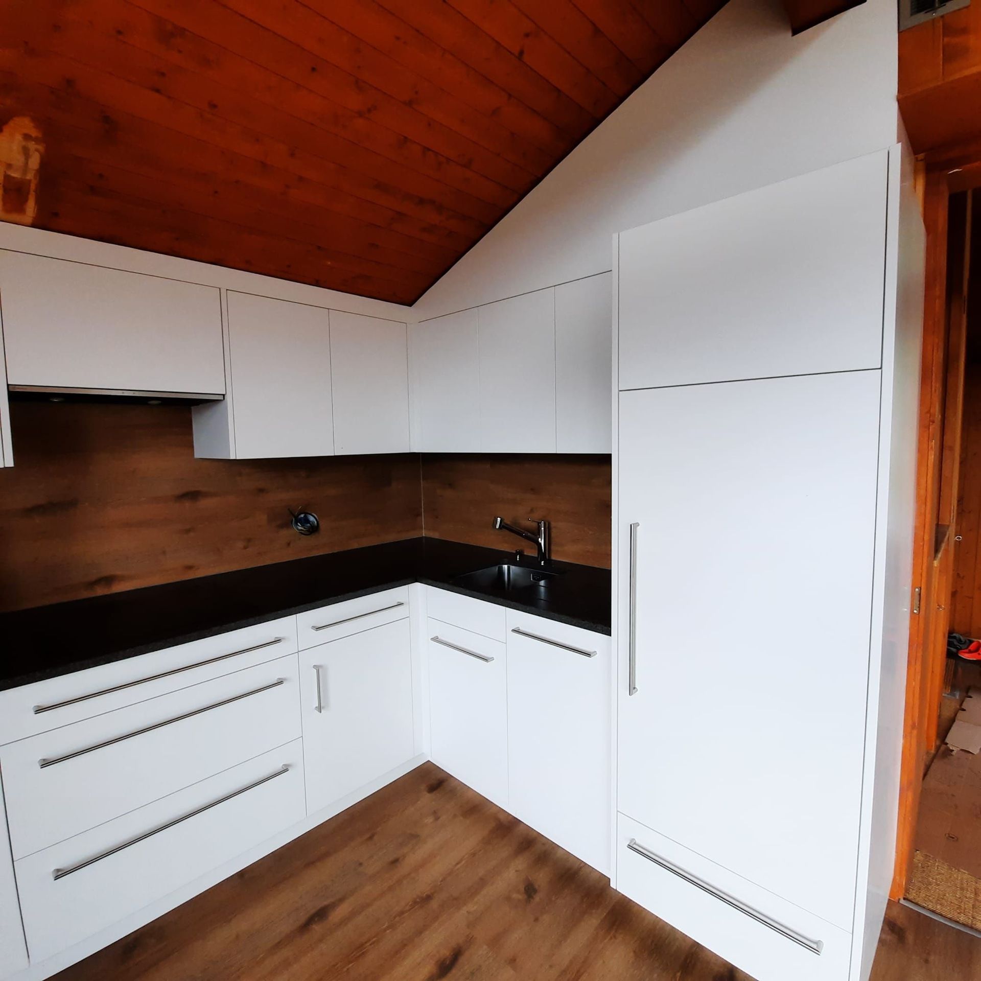 Cuisine en stratifié blanc, granit impala satiné, entre meuble en vinyle idem sol