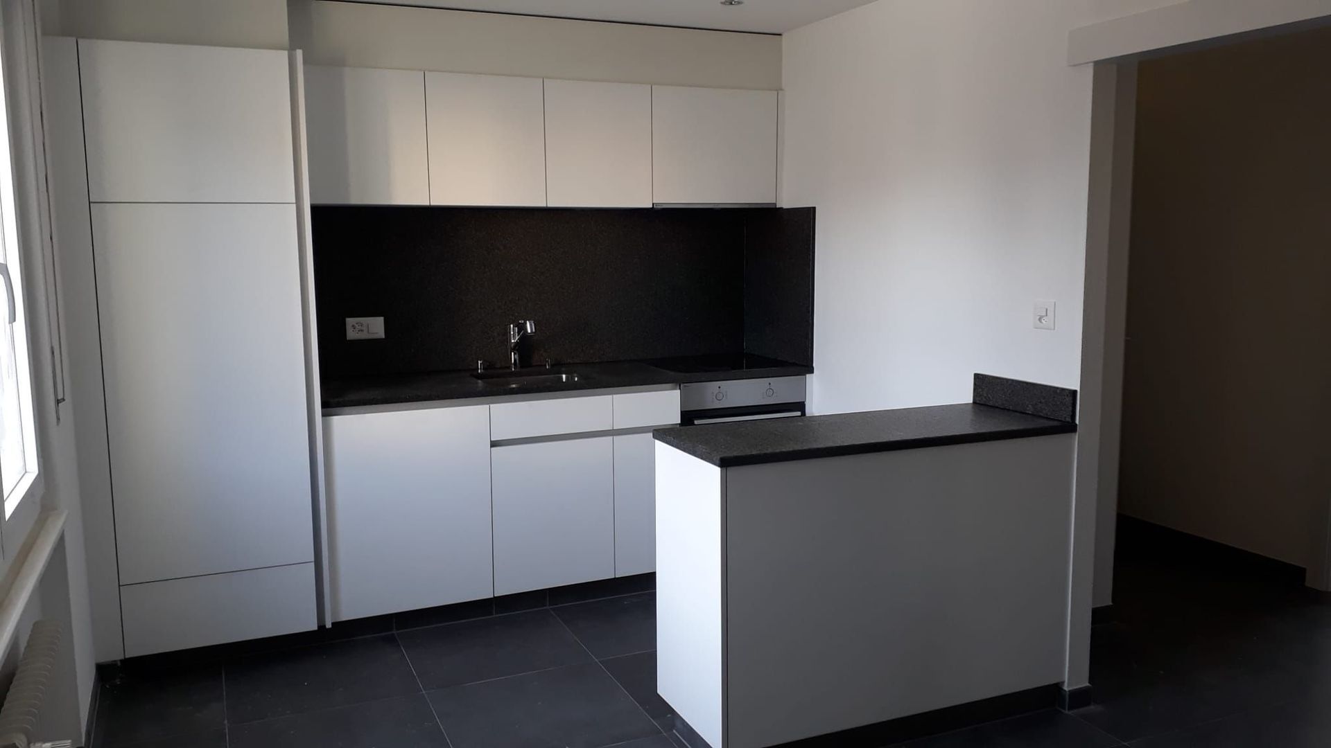 Cuisine en stratifié blanc avec plan de travail en granit, poignées intégrées