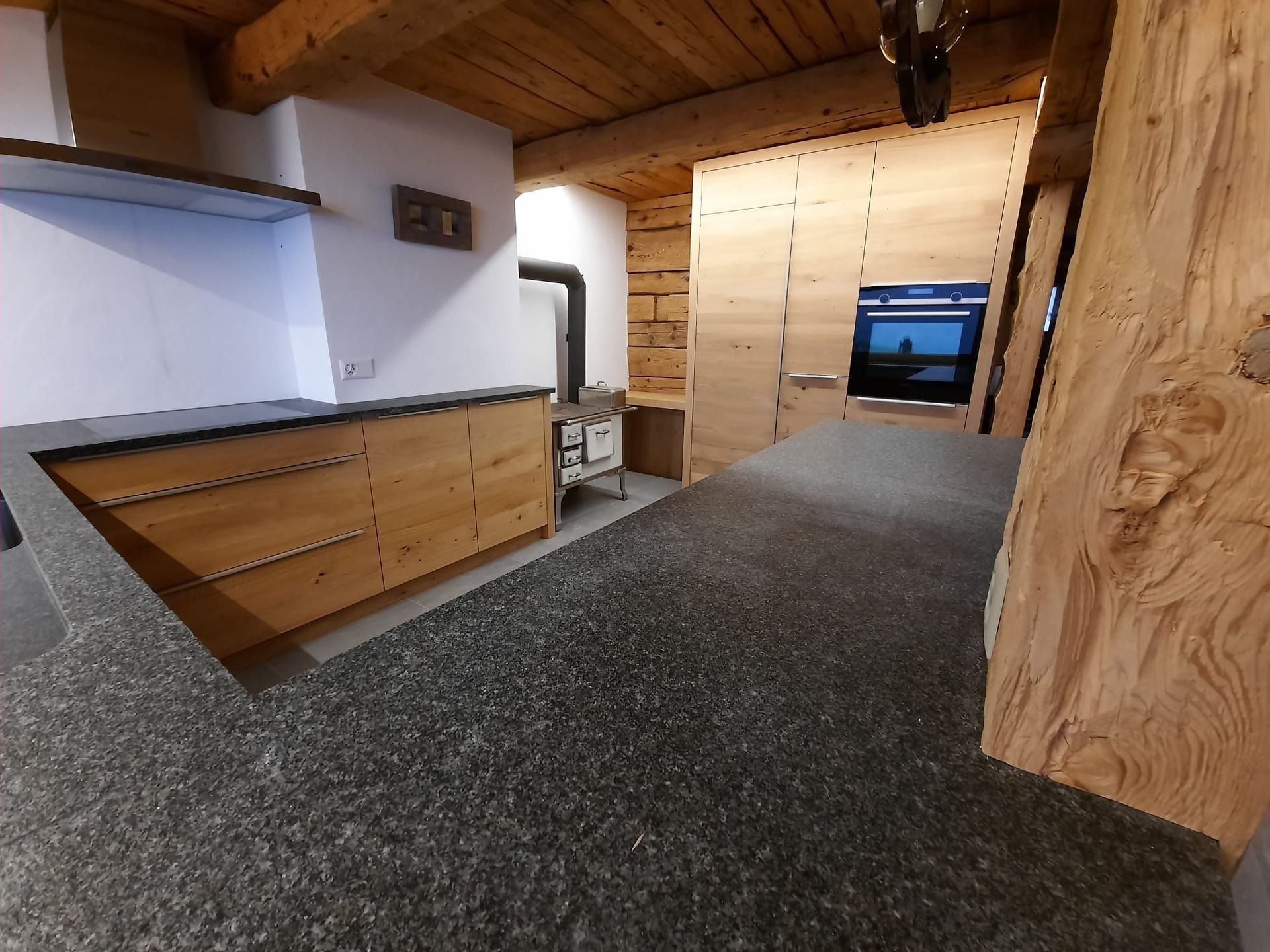 Cuisine neuve en chêne dans un chalet rénové rempli de charme - Plan de travail Impala, champs bruts - poignées inox