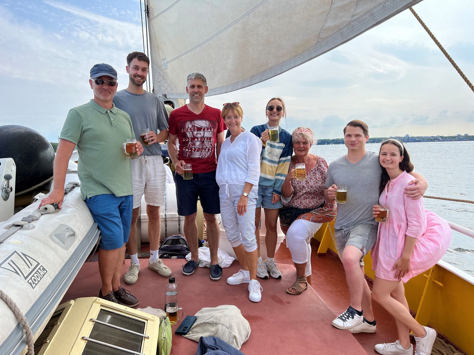 eine Gruppe von Menschen steht auf einem Boot und hält Bier in ihren Händen