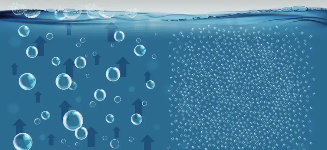 Gráfico de agua azul con burbujas ascendentes a la izquierda y finas partículas blancas a la derecha.