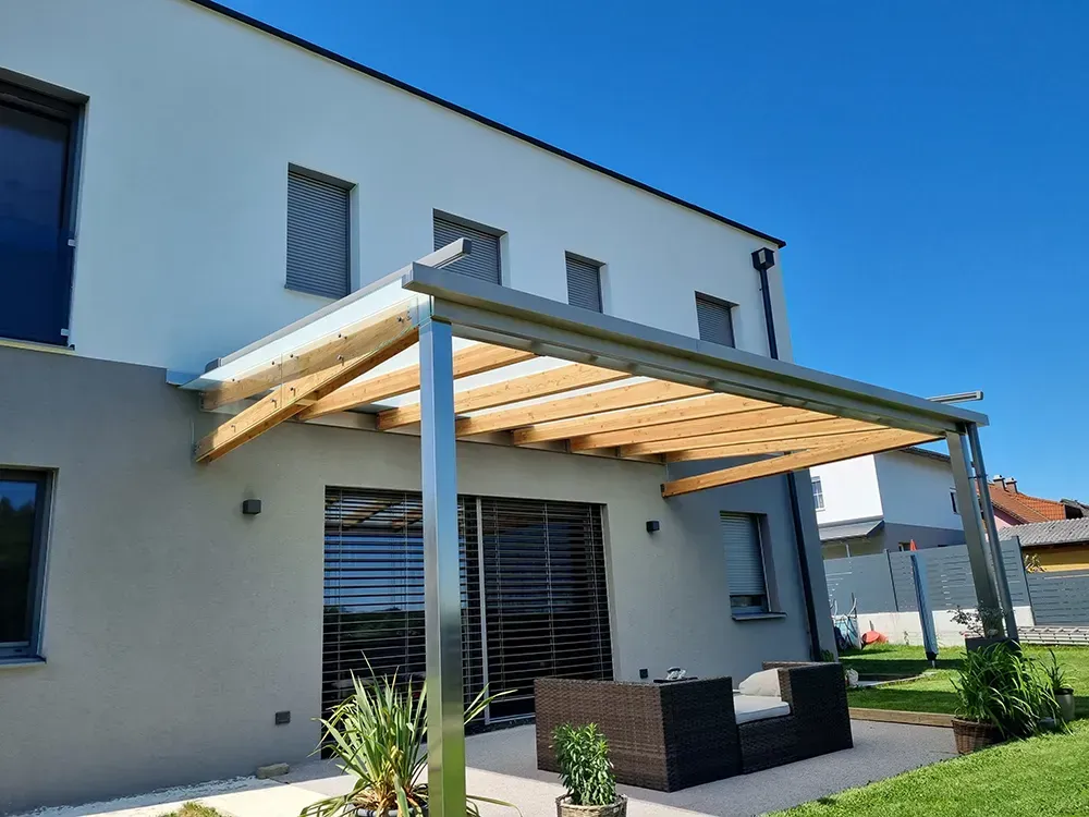 Ein Haus mit einer hölzernen Pergola an der Seite.