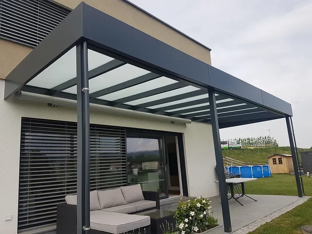 Eine Terrasse mit einer Couch und einem Tisch unter einem Baldachin.