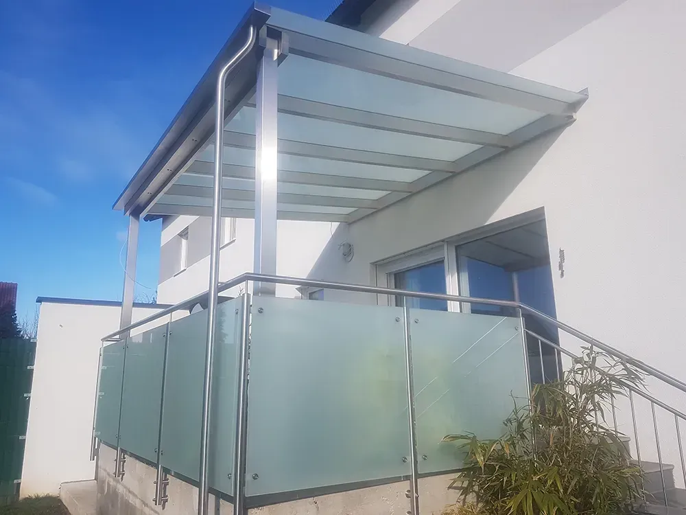 Ein Balkon mit Glasdach und Edelstahlgeländer