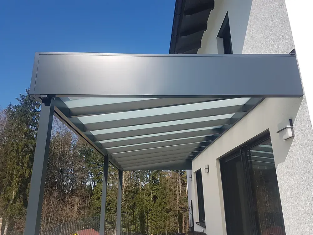 Ein Haus mit einer Pergola an der Seite