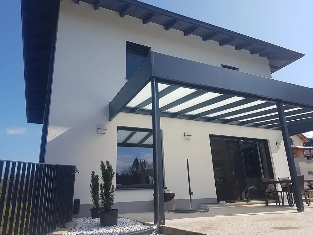 Ein weißes Haus mit einer Pergola an der Vorderseite.