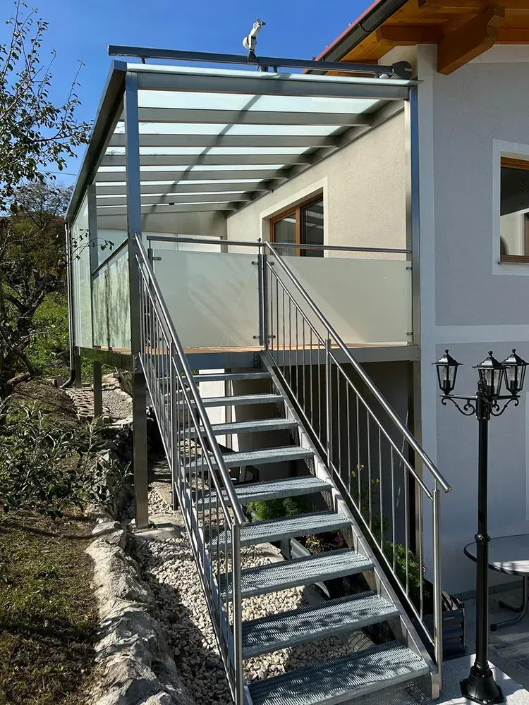 Eine Treppe, die zu einem Balkon an der Seite eines Hauses führt.
