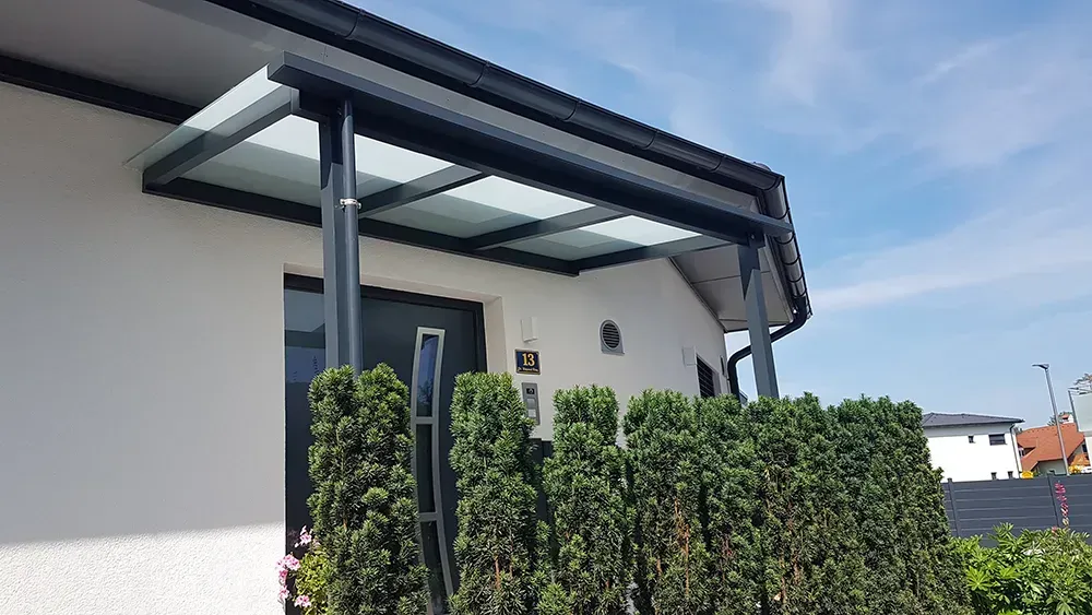 Ein weißes Haus mit einem Glasdach über der Eingangstür.