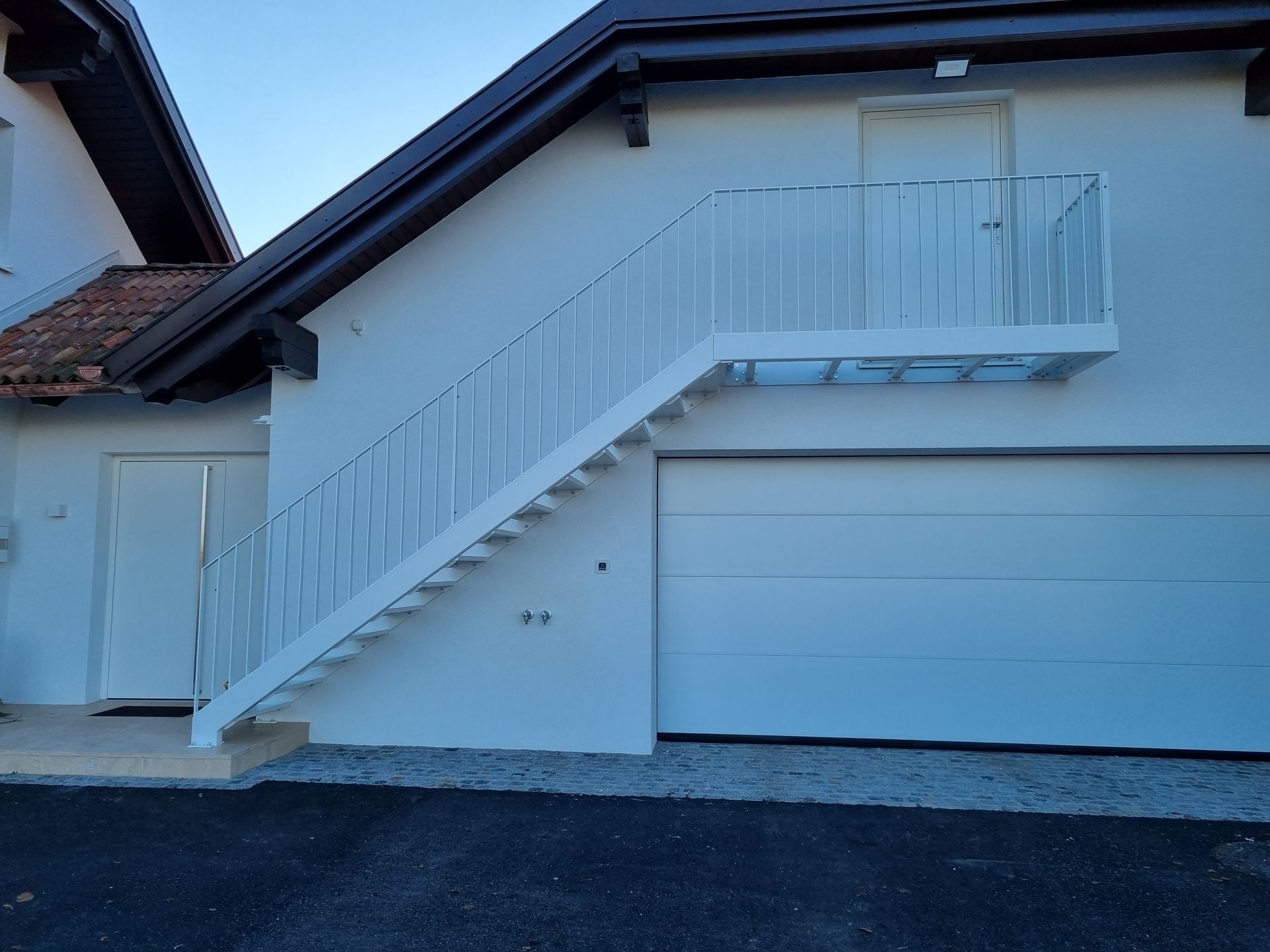 Ein weißes Haus mit einer Treppe, die in den zweiten Stock führt