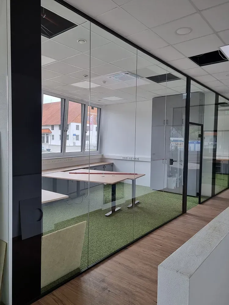 Ein Raum mit einer Glaswand und einem Tisch darin.