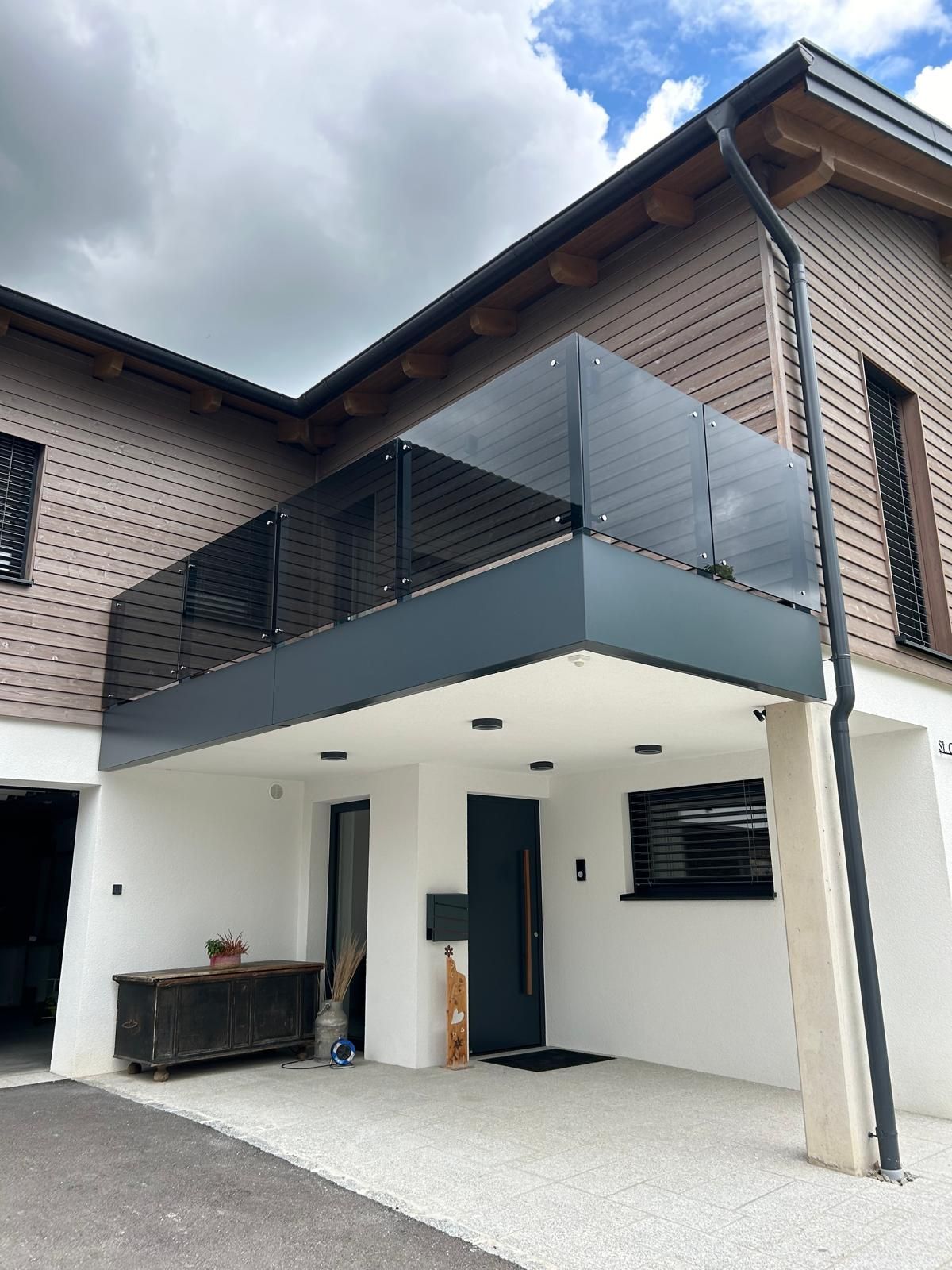 Ein großes Haus mit einem Balkon und einer schwarzen Tür