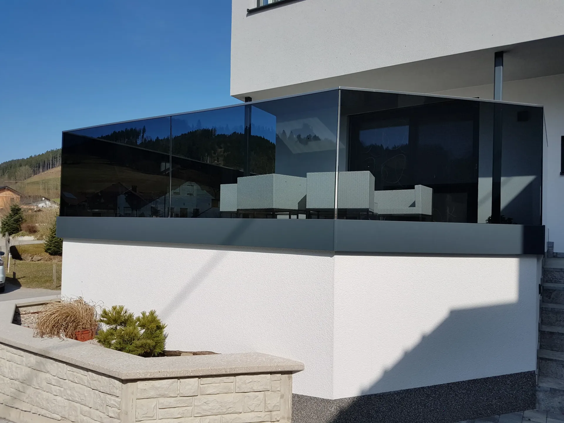 Ein weißes Gebäude mit einem Glasgeländer an der Seite.