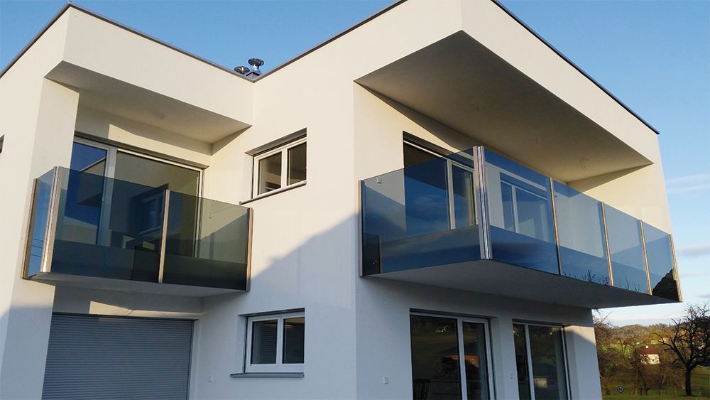 Ein weißes Haus mit Balkon und Garage.