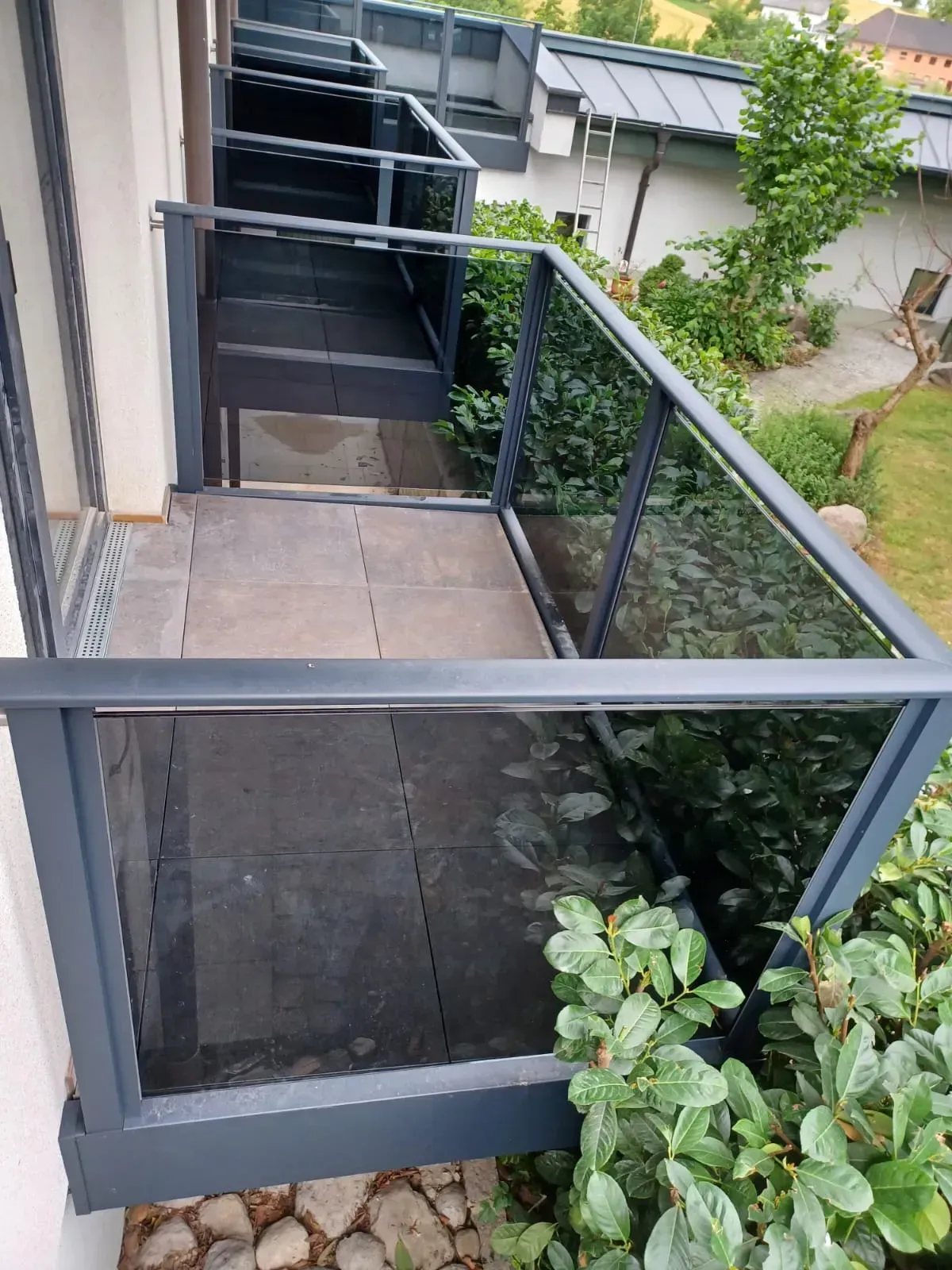 Ein Balkon mit Glasgeländer und Treppe, die dorthin führt