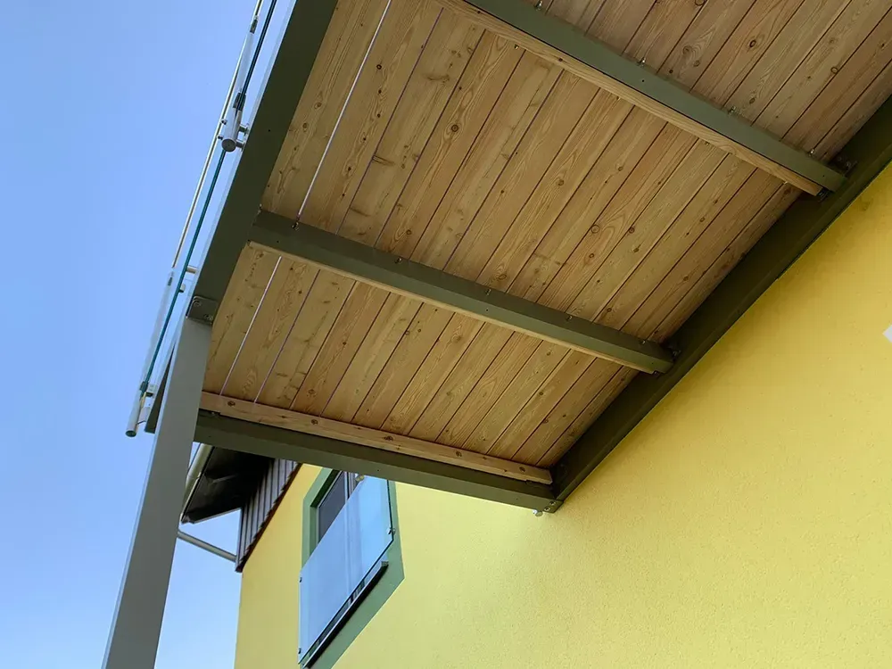 Ein gelbes Gebäude mit einem Holzdeck darauf