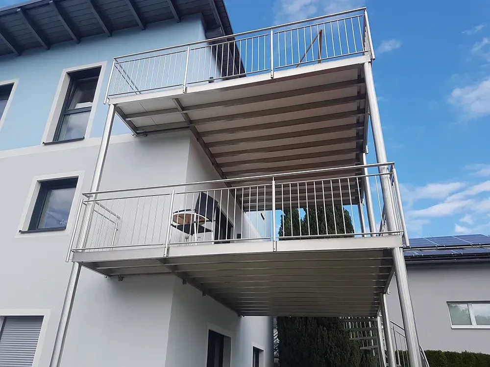 Ein Balkon an der Seite eines Gebäudes mit einem blauen Himmel im Hintergrund.