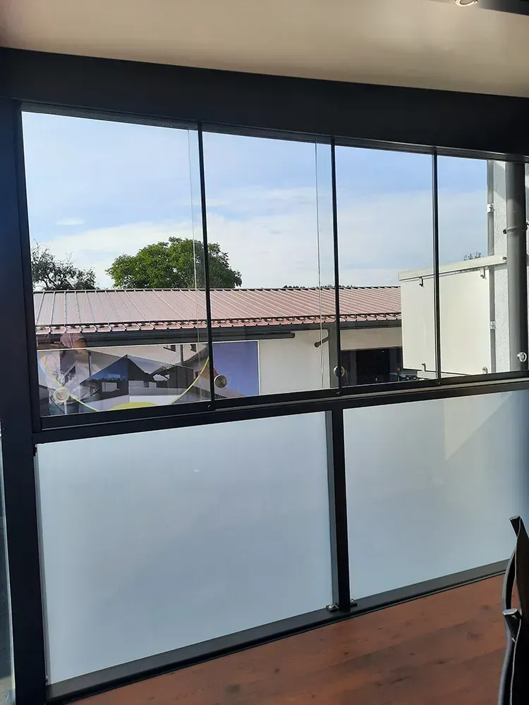 Ein Raum mit vielen Fenstern und Blick auf ein Gebäude.