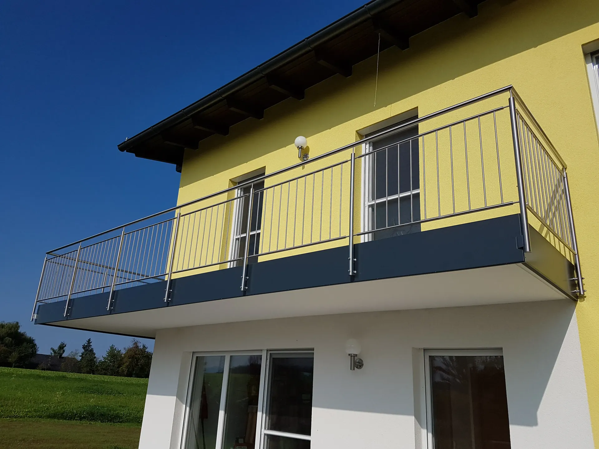 Ein gelb-weißes Haus mit einem Balkon im zweiten Stock