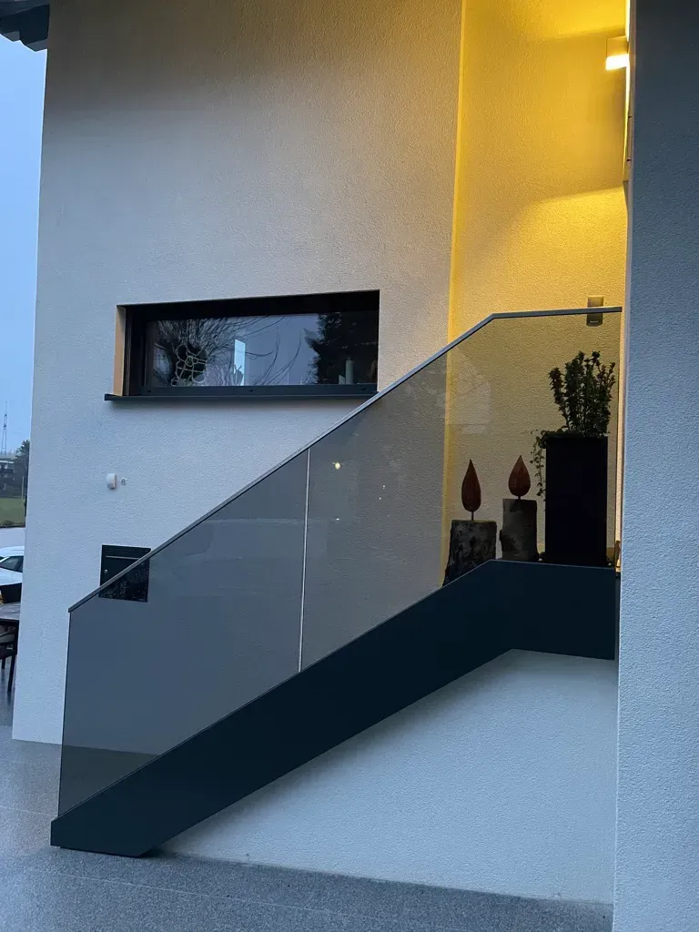 Eine Treppe mit Glasgeländer und Fenster