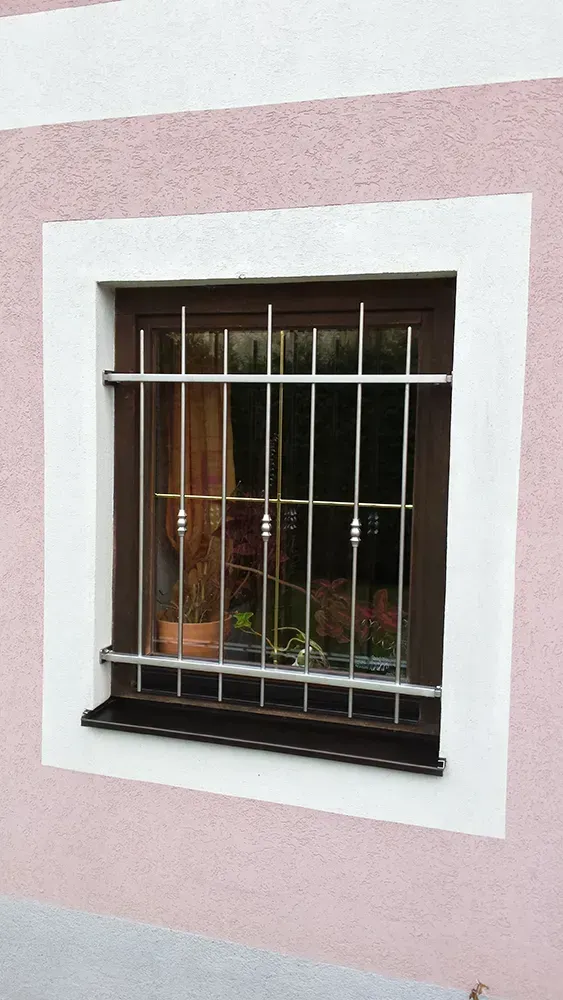 Ein Fenster mit einem Edelstahlgitter darauf