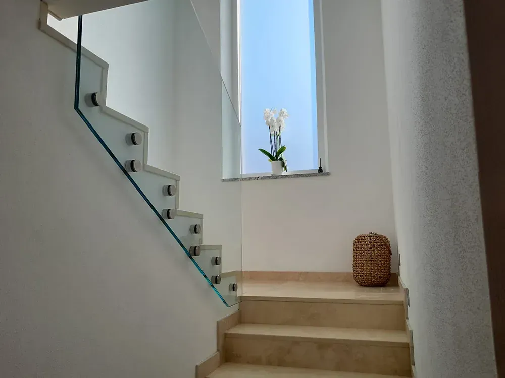 Eine Treppe mit Glasgeländer und Fenster