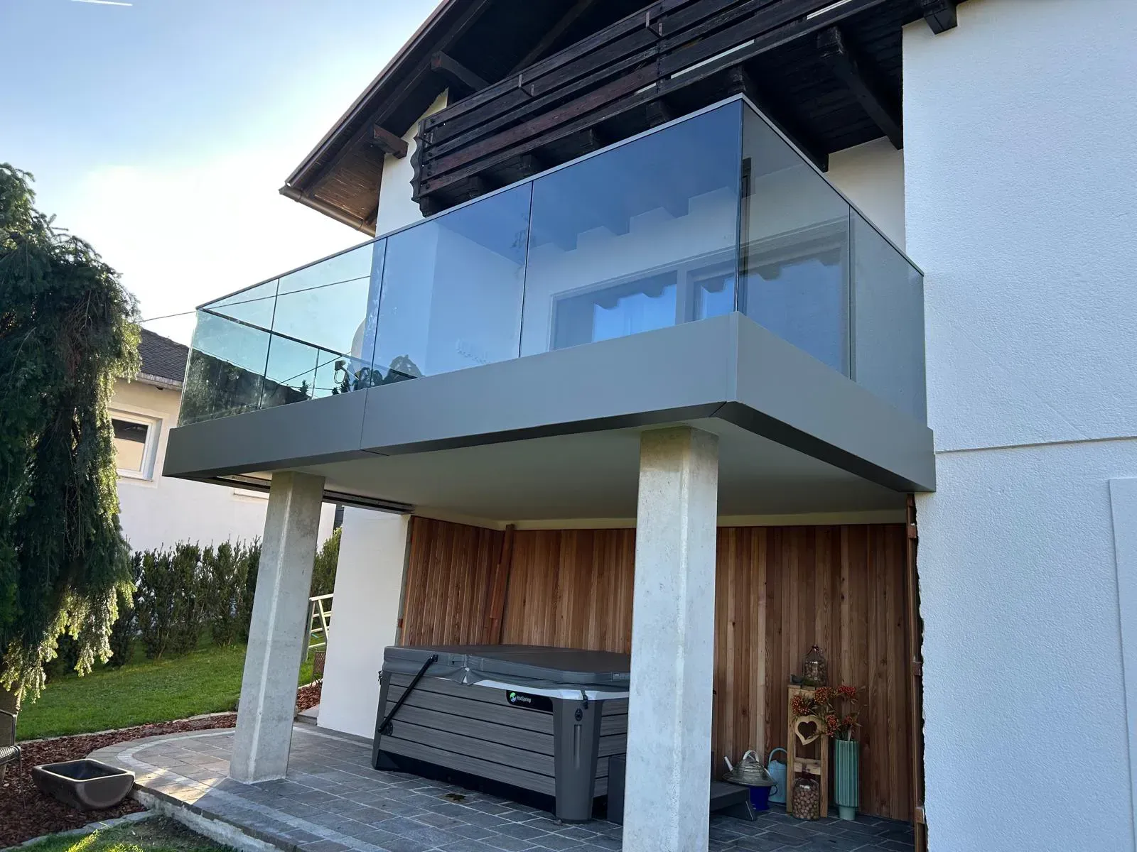 Ein Balkon mit einem Glasgeländer an der Seite eines Hauses.